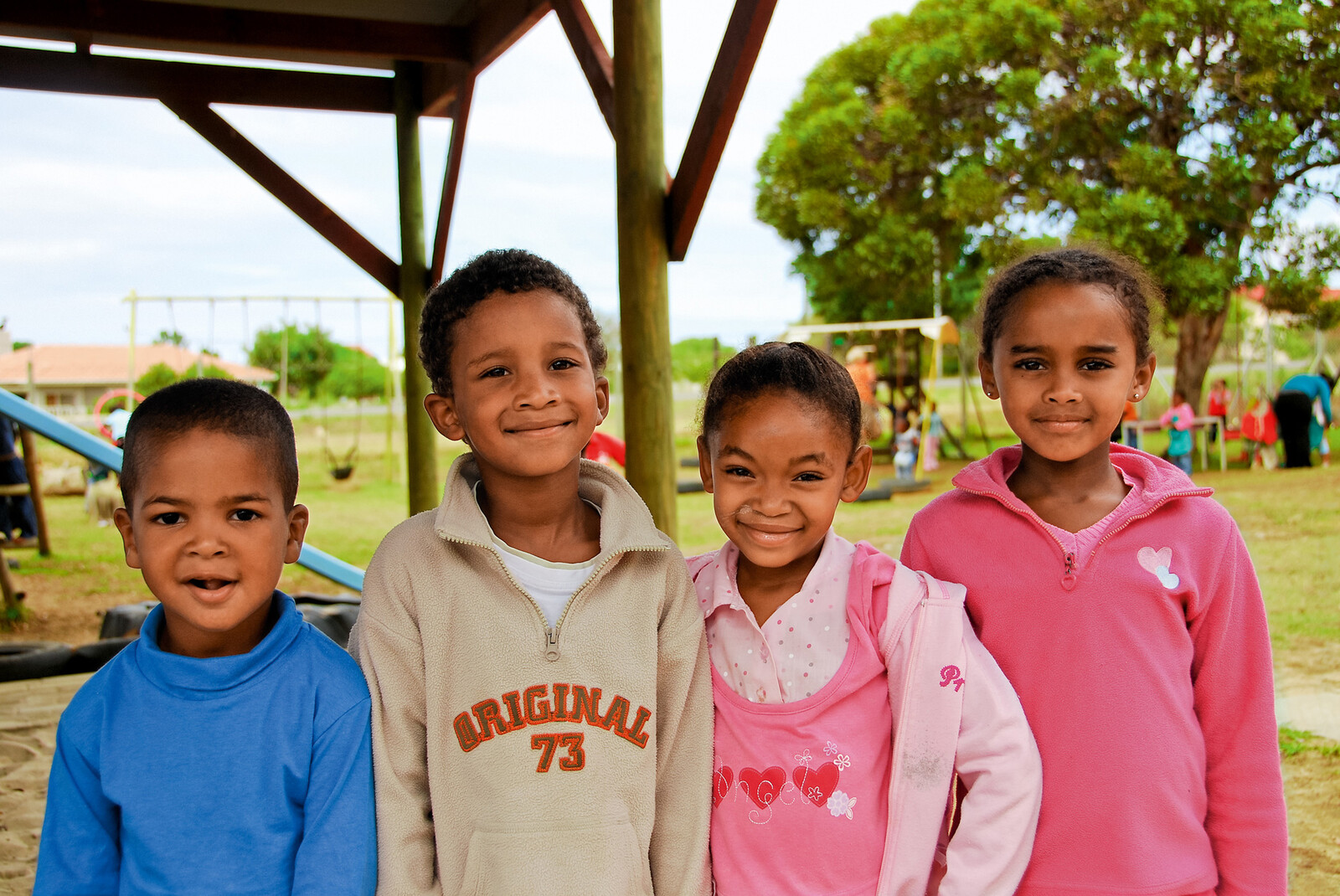 African children stand in a playground and laugh at the camera. The project they are involved in is called For Smiling Children. It is supported by the Grand Resort Bad Ragaz, a star hotel in Switzerland.